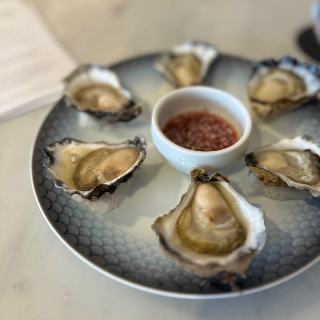 Opened oysters on a plate with sauce