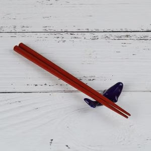 A pair of chopsticks resting on Whale Chopstick Rest